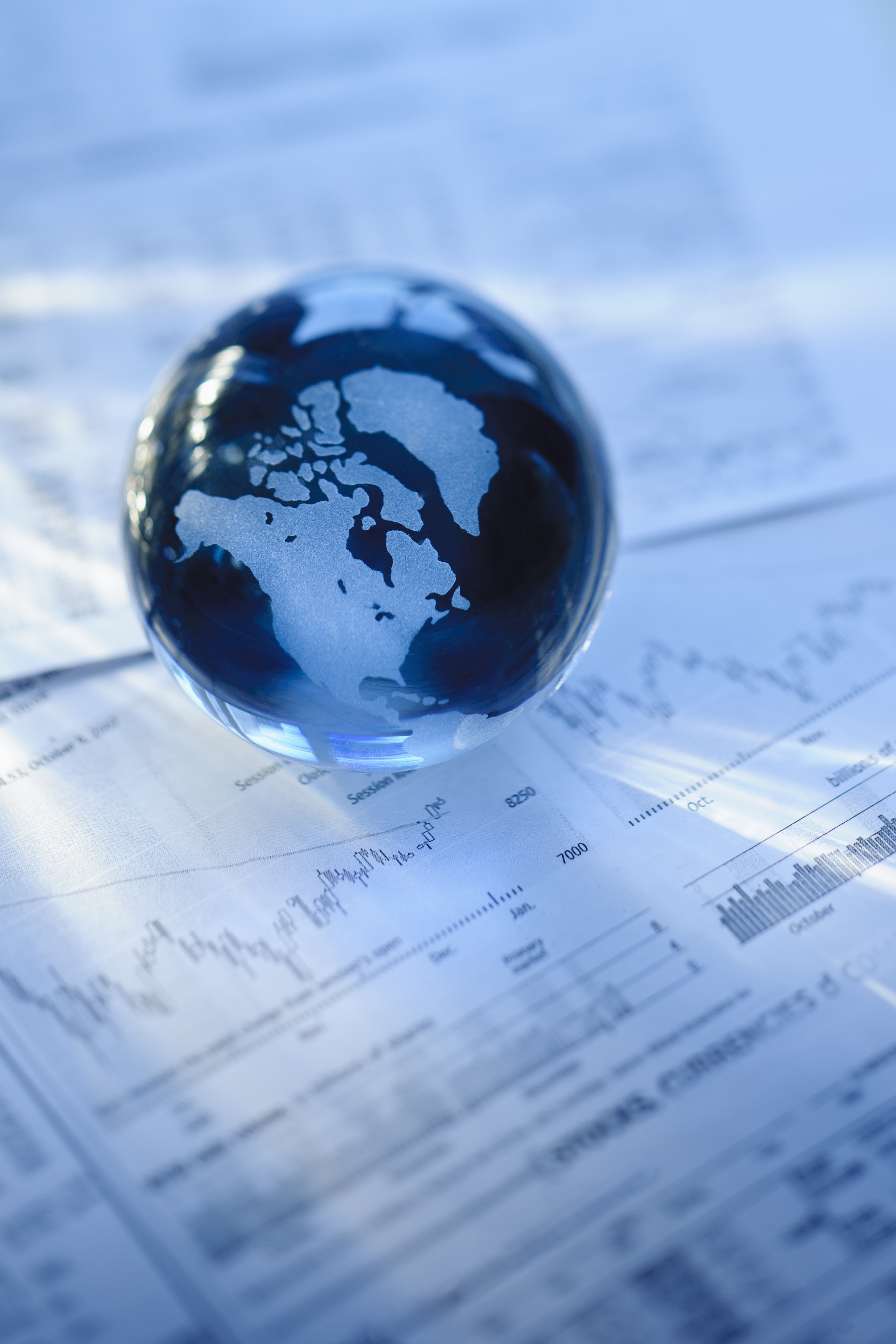 image of a marble-sized globe sitting on a pile of paperwork