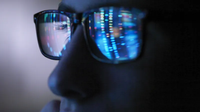 man looking at computer screen wearing glasses