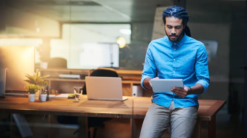 Man sitting on a desk reading information