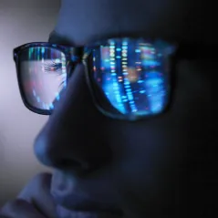 man looking at computer screen wearing glasses
